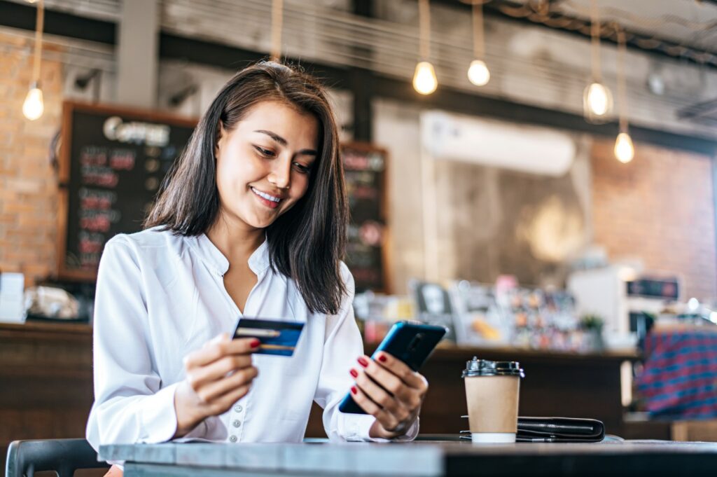 Cliente satisfeita durante pagamento de compra para ilustrar dicas de ações para o Dia do Cliente